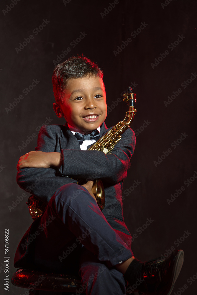 Fototapeta premium six years old boyhug his saxophone