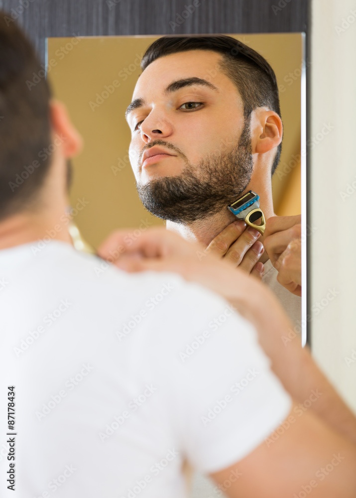 Fototapeta premium Man shaving the beard with a razor