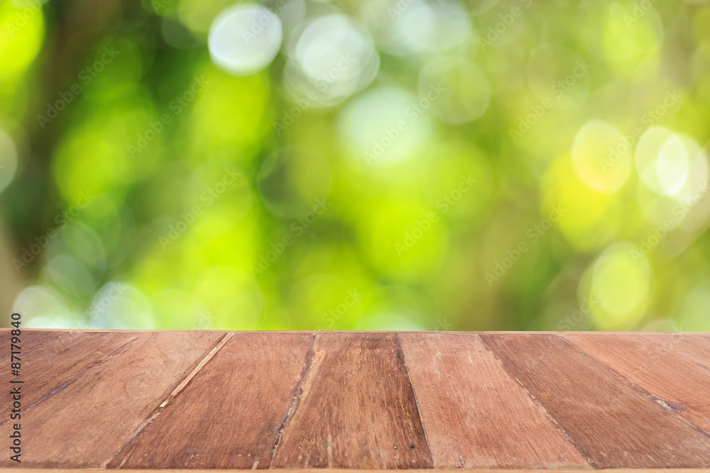 Top wooden table with sunny abstract green nature background, bl Top wooden table with sunny abstract green nature background, bl