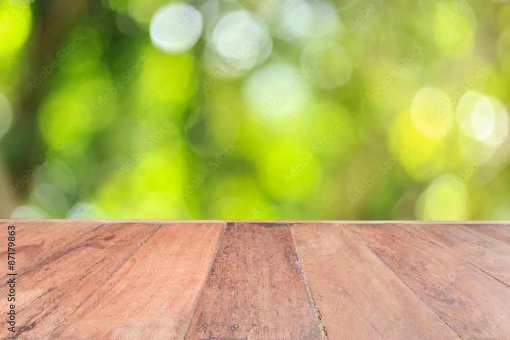 Top wooden table with sunny abstract green nature background, bl Top wooden table with sunny abstract green nature background, bl