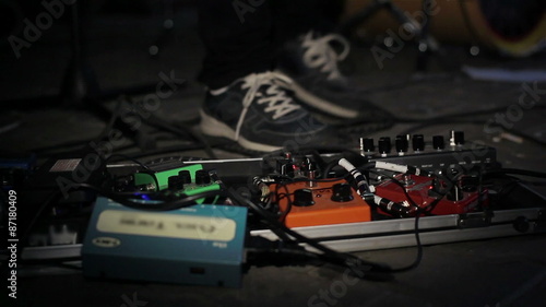 Close up of guitar players foot pressing pedal board photo