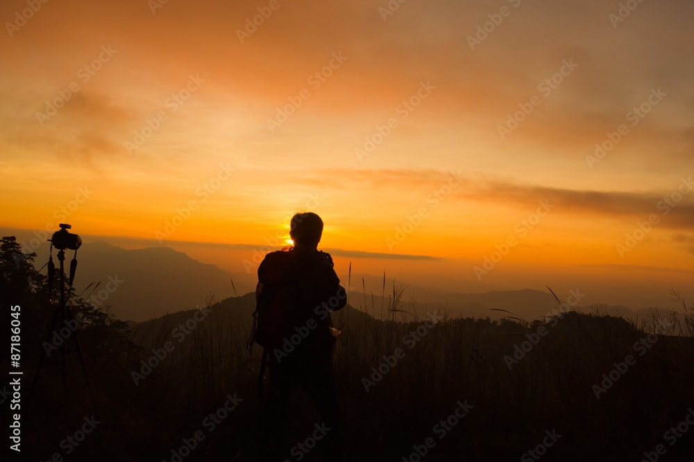 silhouette of photographer taking picture of landscape during sunset