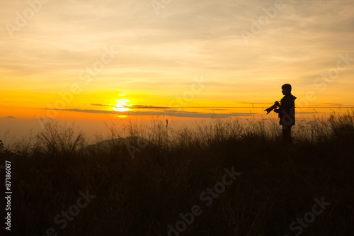 silhouette of photographer taking picture of landscape during sunset © khlongwangchao