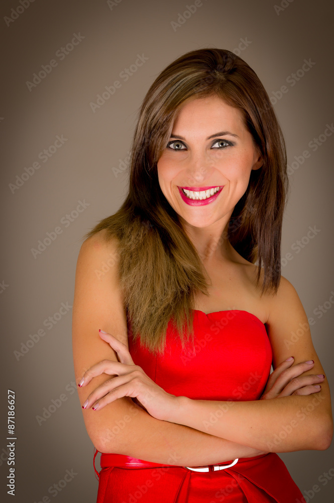 Hispanic female model posing for camera in studio facing lens and arms crossed smiling Hispanic female model posing for camera in studio facing lens and arms crossed smiling