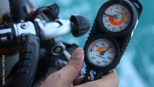 instructor turns on stopcock of aqualung checks pressure	