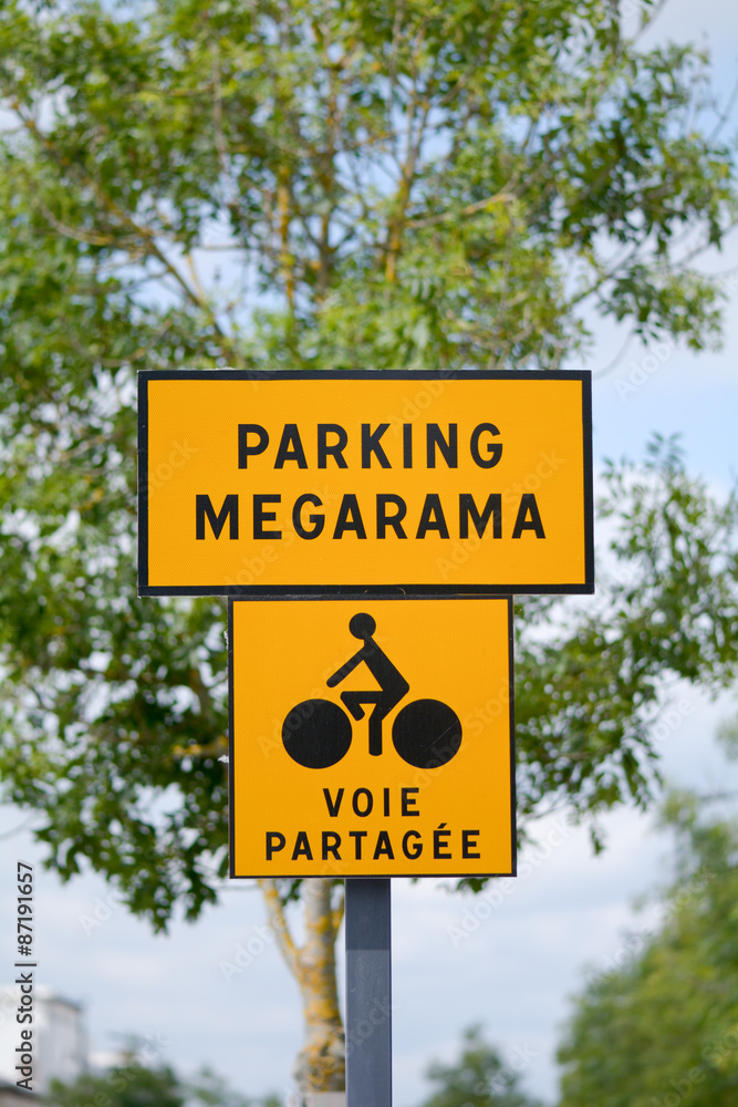 Parking Megarama and shared lane with cyclists signs outside car