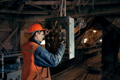 Bilde på lerret Miner worker man in a helmet at the control operator of the mine.