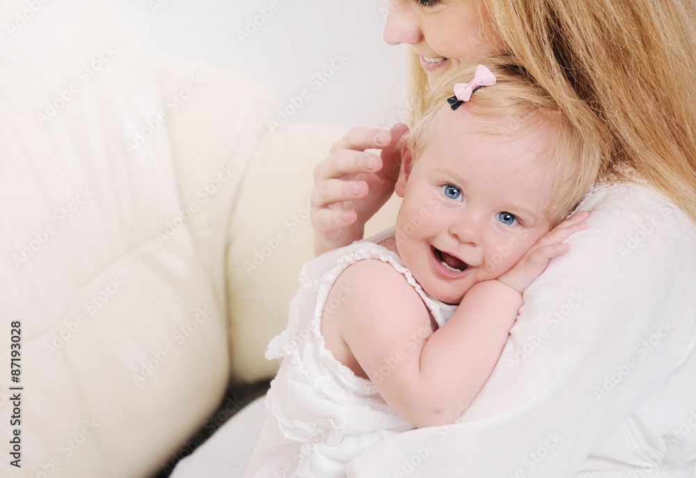 mother and her cute little baby girl having fun on the sofa mother and her cute little baby girl having fun on the sofa