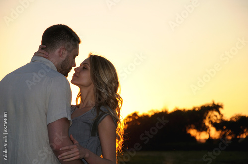 romantic sensual young couple in love posing at the sunset