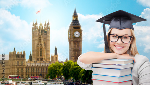 Photography student in trencher cap with books over london