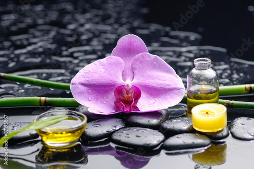 Pink orchid and green leaf with candle,oil on therapy stones photo