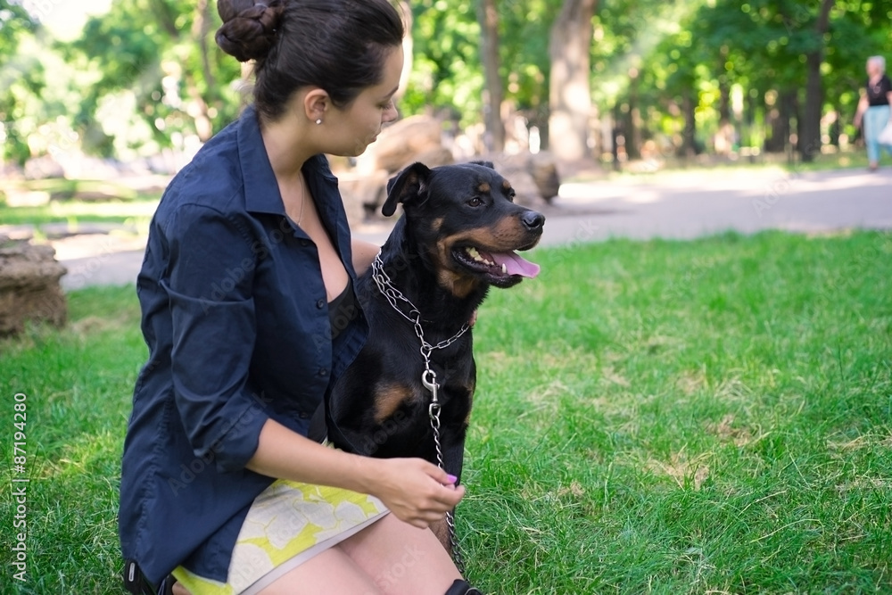 A beautiful woman walks in the park Rottweiler
