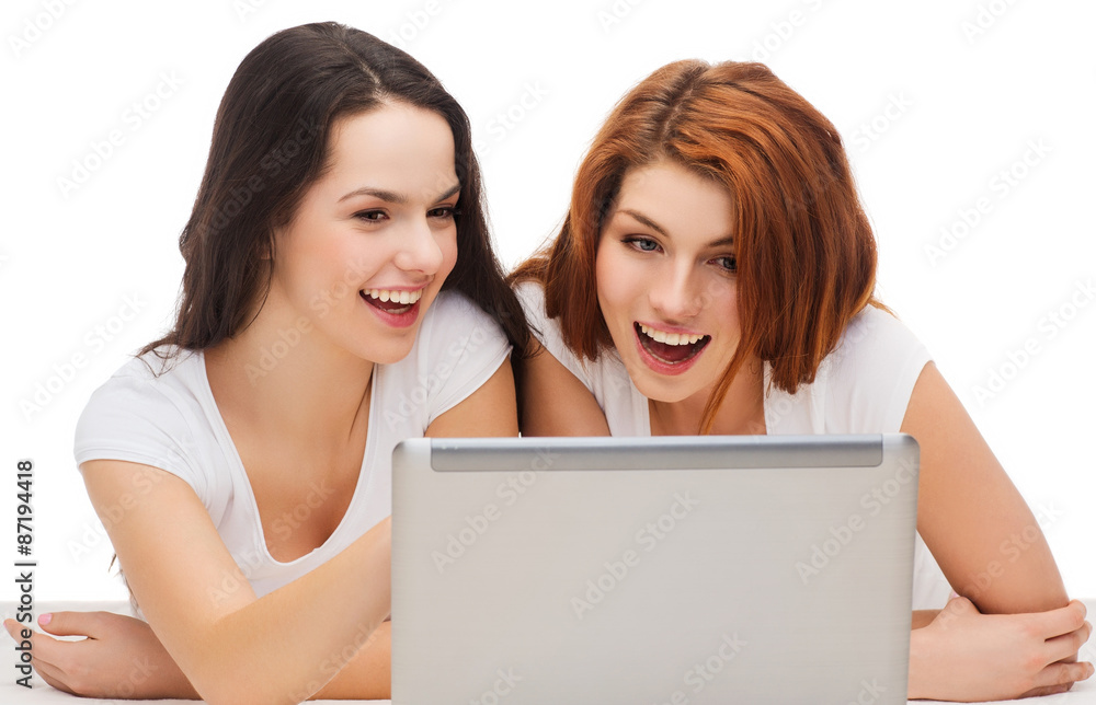 two smiling teenage girsl with laptop computer two smiling teenage girsl with laptop computer