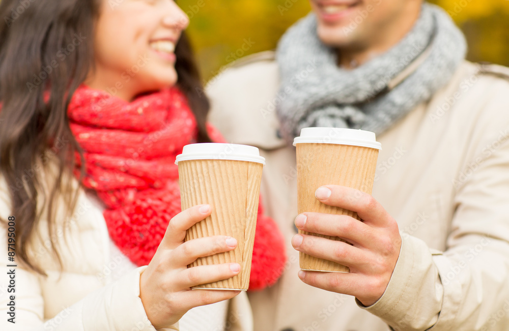 smiling couple with coffee cups in autumn park smiling couple with coffee cups in autumn park