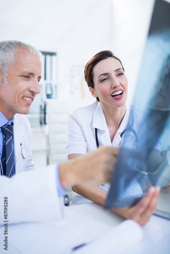 Smiling medical colleagues examining x-ray together Smiling medical colleagues examining x-ray together