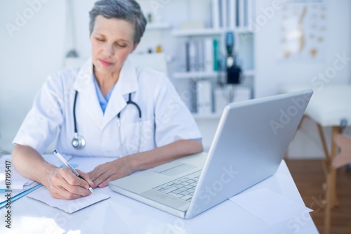 Female doctor writing on paper 