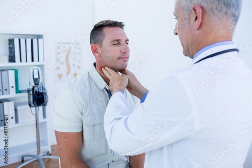 Doctor examining his patient neck 