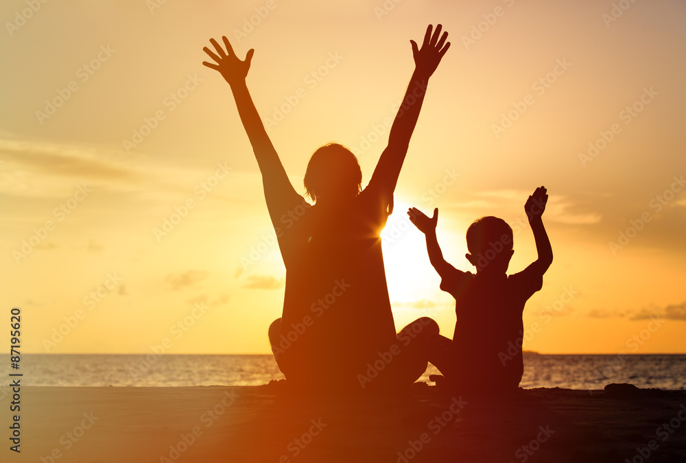 Silhouette of happy father and son at sunset