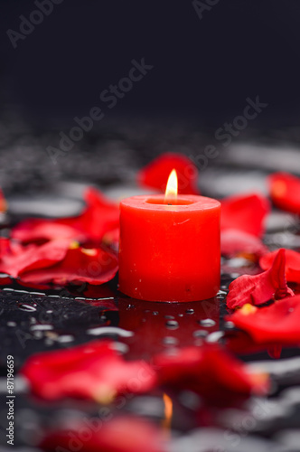 Still life with red rose petals with pink candle and therapy stones 