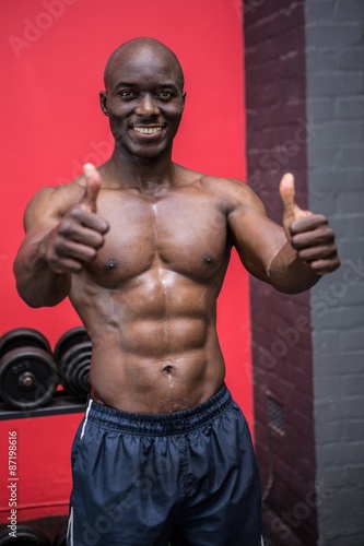 Young bodybuilder gesturing with thumbs up
