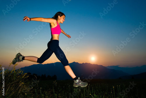 Girl jumping at sunset in the mountains