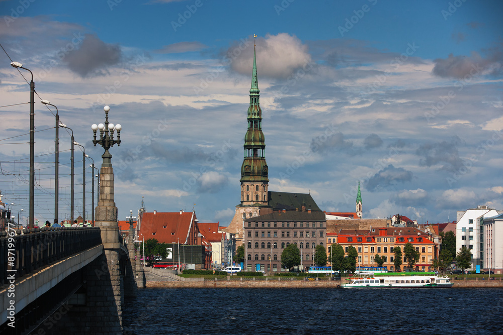 Naklejka premium Quay Riga with St. Peter and the ships on the river in the summe
