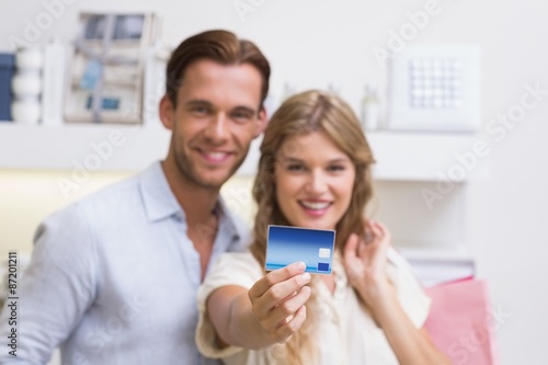 Portrait of a happy couple showing their new credit card