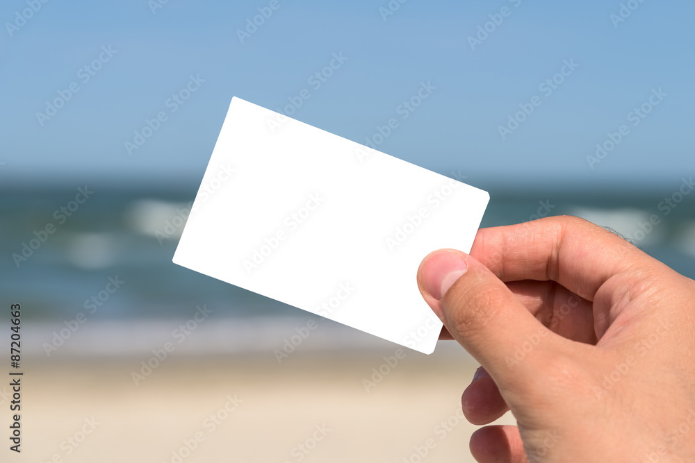 Man Hand Holding Blank White Card On Beach In Summer Man Hand Holding Blank White Card On Beach In Summer