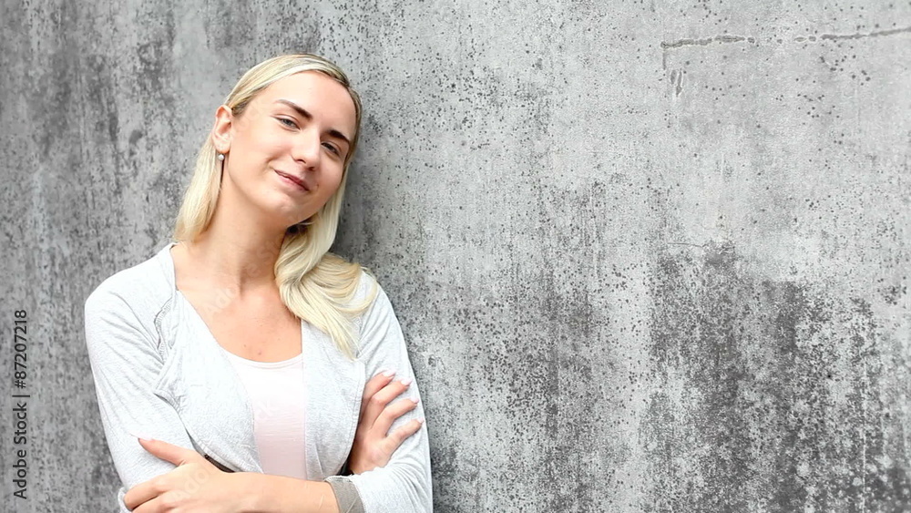 Attractive young woman leaning to concrete wall Attractive young woman leaning to concrete wall