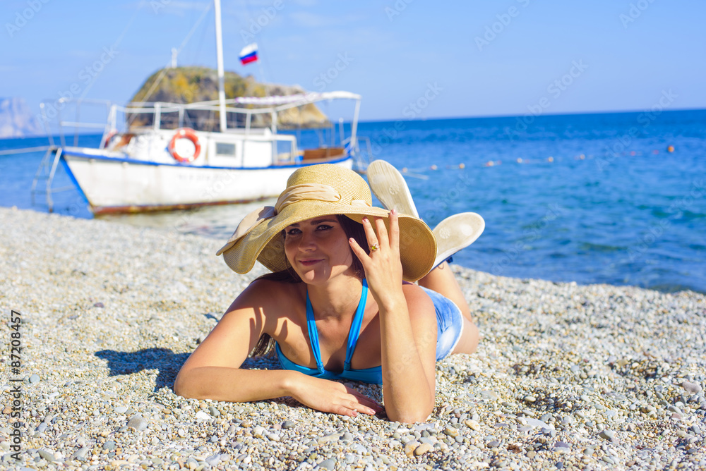 young caucasian female in a hat on the beach