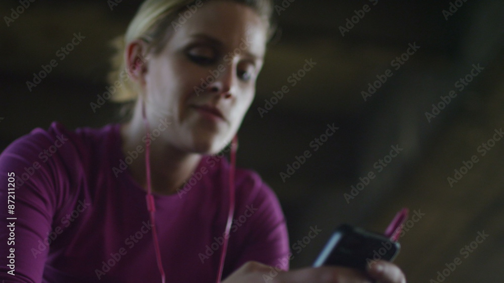 Young female athlete taking a moment to use her phone in slow motion Young female athlete taking a moment to use her phone in slow motion