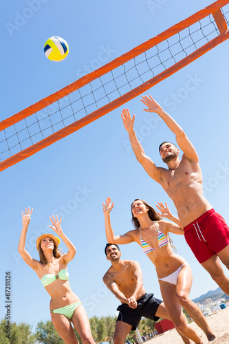 Happy friends playing beach volley
