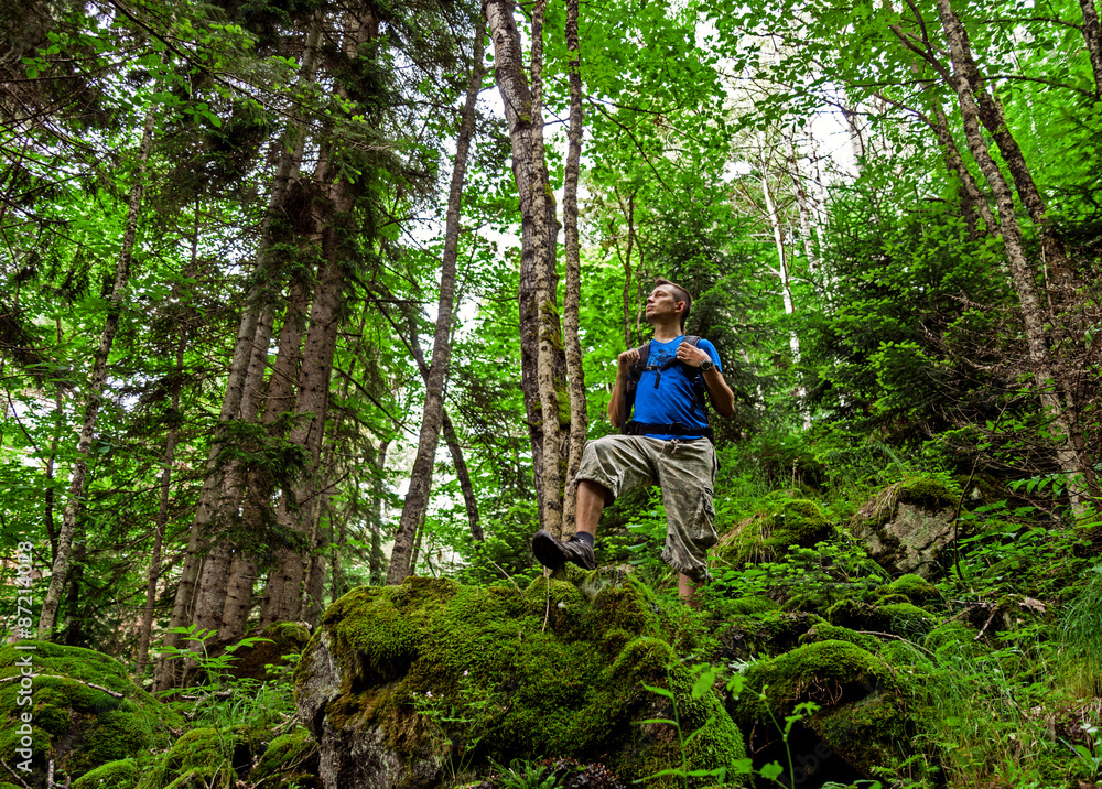 Active healthy man hiking in beautiful mountains forest