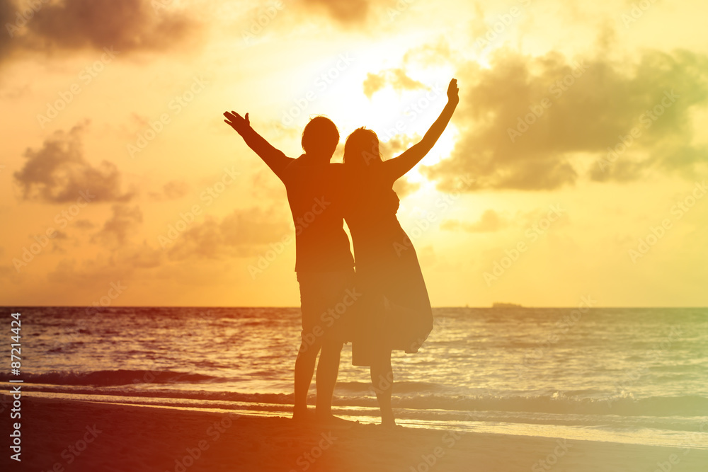Happy romantic couple on the beach at sunset