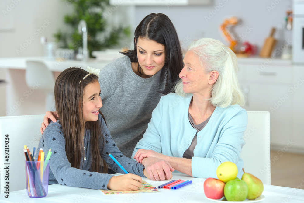 Little girl drawing with mother and grandma Little girl drawing with mother and grandma