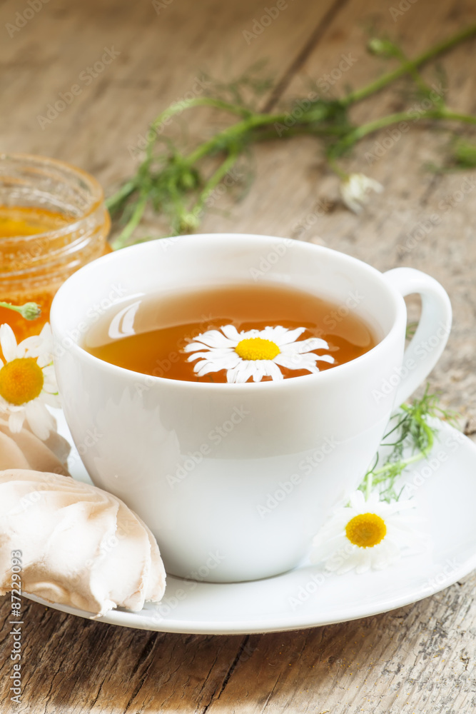Black tea with chamomile, honey and marshmallow, selective focus Black tea with chamomile, honey and marshmallow, selective focus