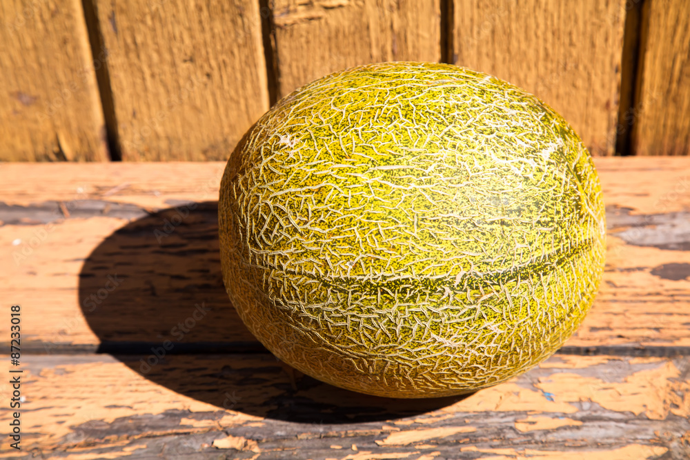 Melon on old weathered wooden surface, outdoors Melon on old weathered wooden surface, outdoors