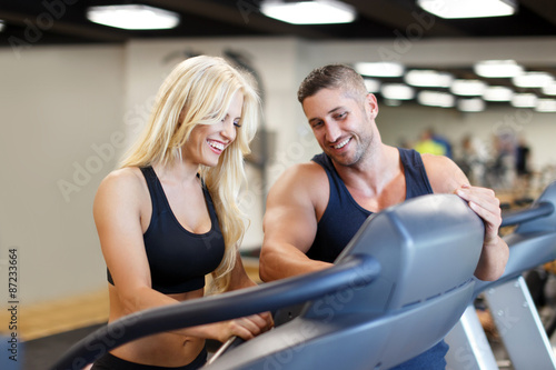 Personal trainer set difficulty on treadmill for woman