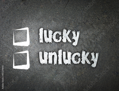 Cuadro en lienzo lucky and unlucky handwritten with white chalk on a blackboard.