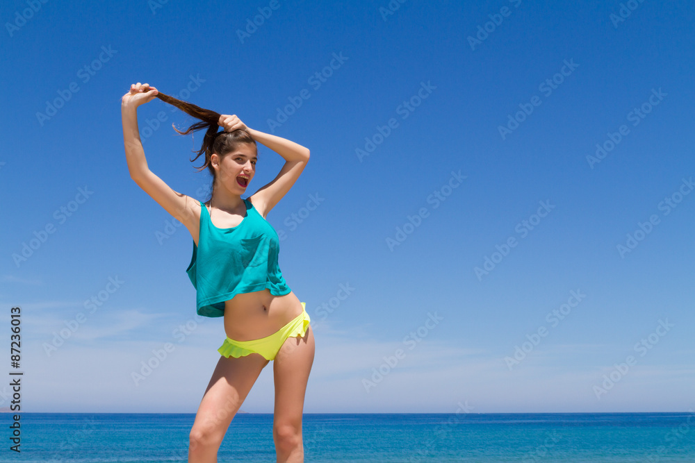 Brunette teen in bikini and beachwear enjoys the summer sun. Brunette teen in bikini and beachwear enjoys the summer sun.