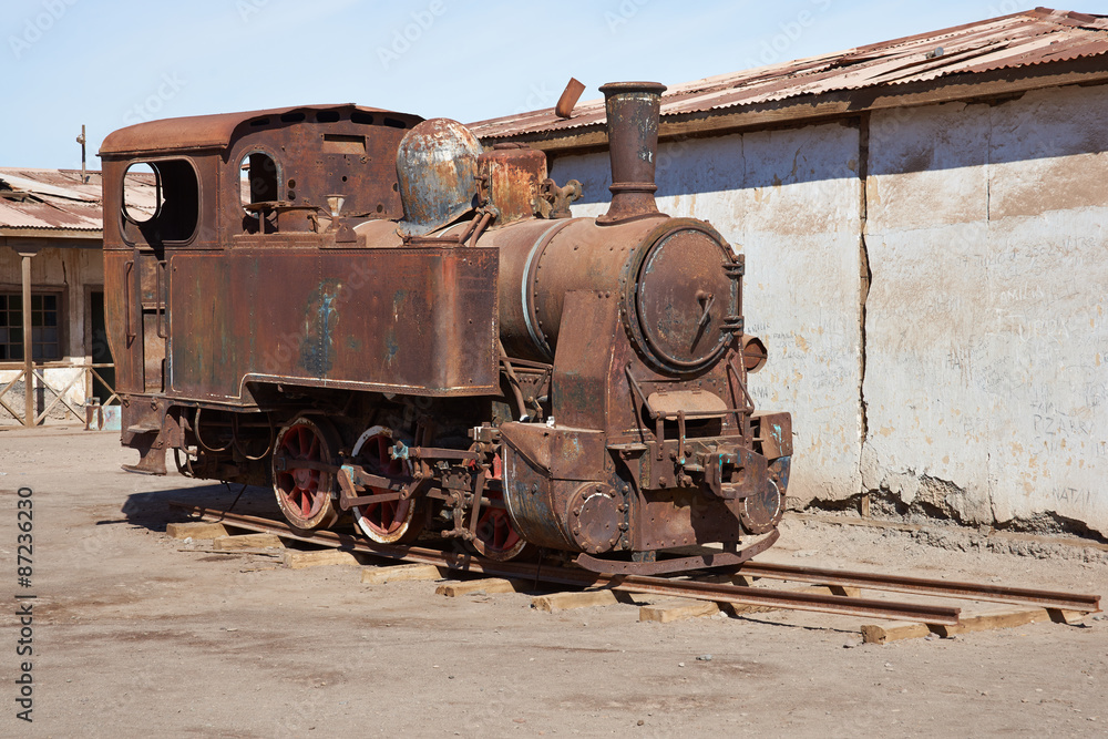 Derelict and rusting steam train at the historic Humberstone Saltpeter Works in the Atacama Desert near Iquique in Chile. The site is now an open air museum and a Unesco World Heritage SIte.
