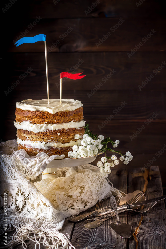 Naked Layer Cake decorated with flags on wooden table.