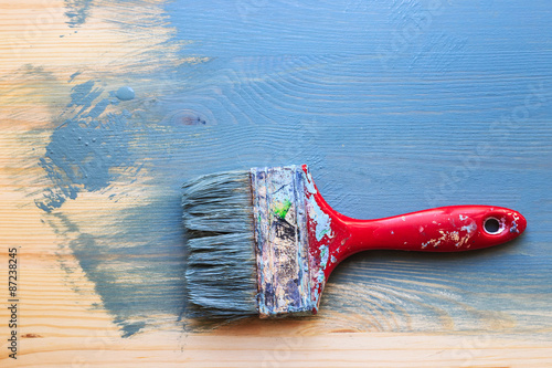 Old used paint brush on partial paint wood background. Horizonta photo