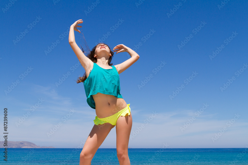 Brunette teen in bikini and beachwear enjoys the summer sun. Brunette teen in bikini and beachwear enjoys the summer sun.