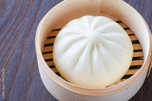 Fotografie Traditional chinese cuisines steamed bun in asian style bamboo basket