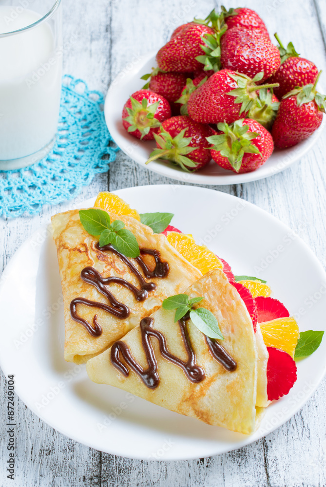Pancakes with sliced strawberries and orange Pancakes with sliced strawberries and orange