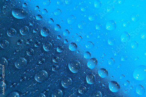 Water drops on the blue surface. Selective focus.