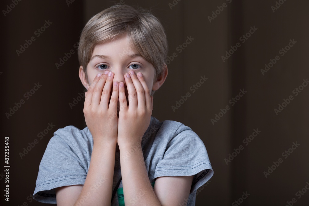 Boy hiding face behind hands Boy hiding face behind hands