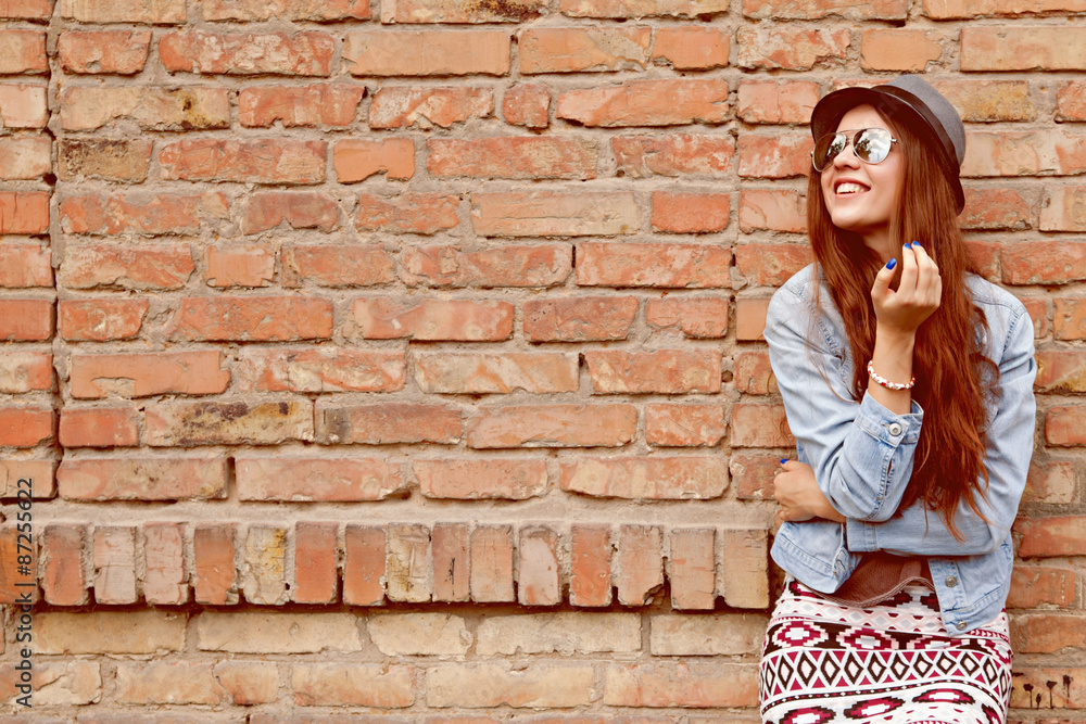beautiful cute teen girl smiling near the brick wall