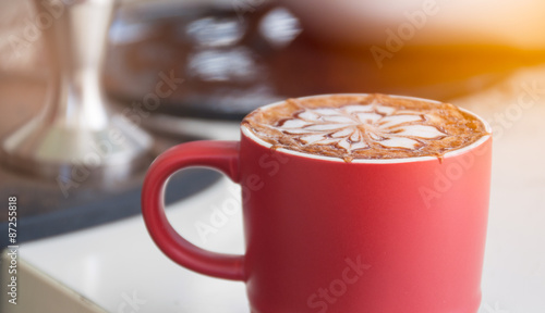 Hot coffee in red cup with counter coffee background